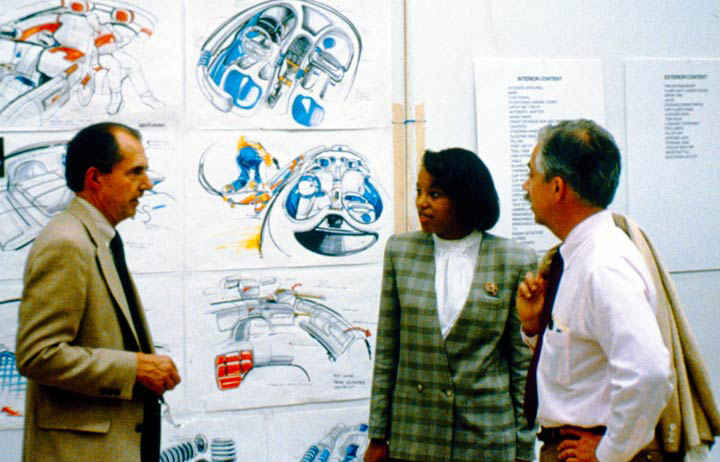 Interior Designer Marietta Kearney Ellis speaking with 2 unidentified GM designers GM Archives