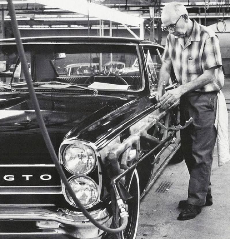 A factory worker applies a stripe to a 1965 Pontiac GTO 3